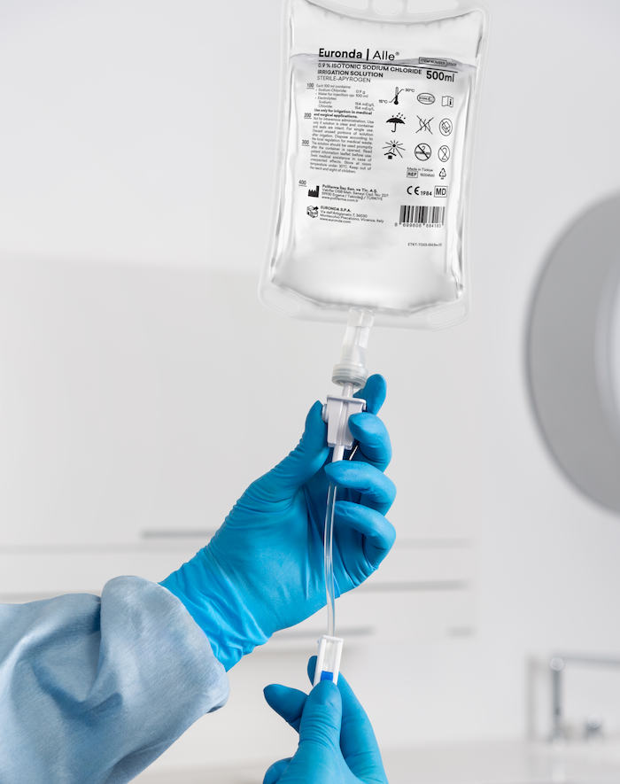 500ml-Beutel Kochsalzkösung aufgehängt mit eingeschobenem Kühlmittelschlauch